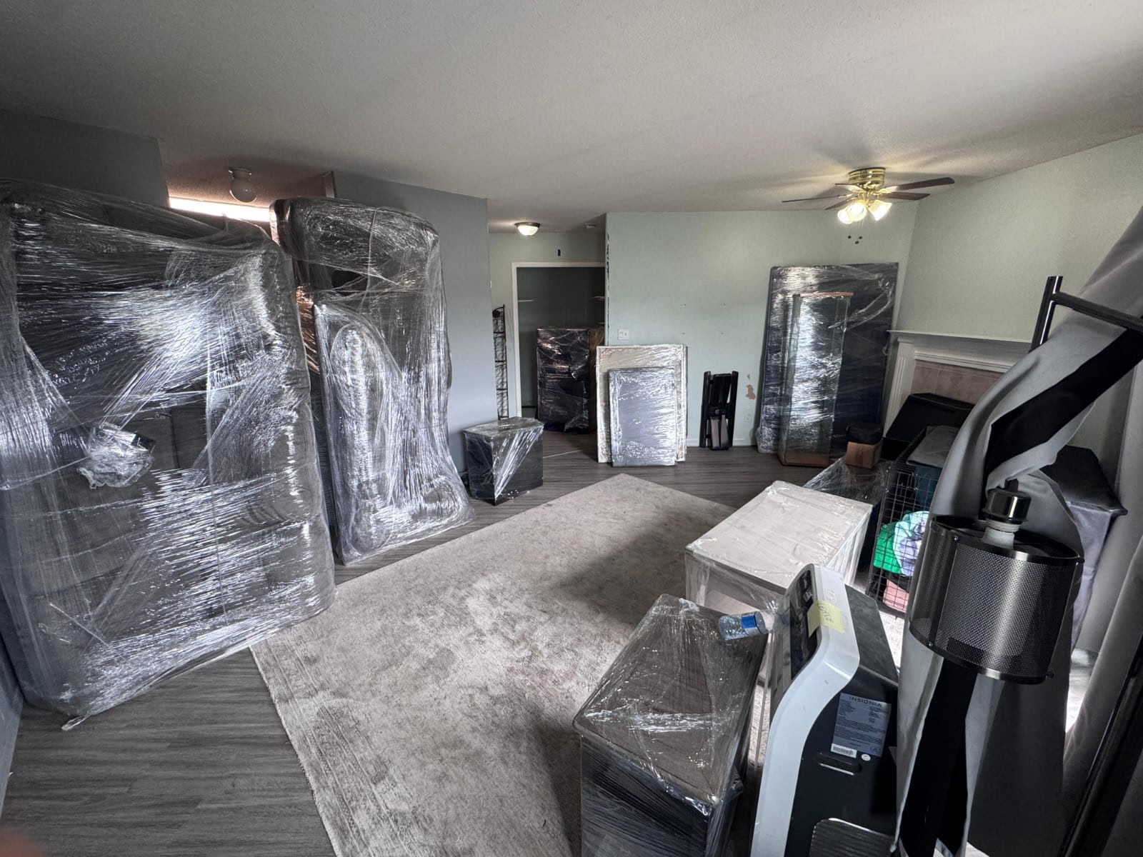 A living room of furniture carefully shrink-wrapped and ready to move